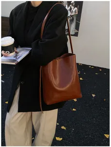 Detail of the brown leather bucket bag shown in a stylish street lifestyle setting