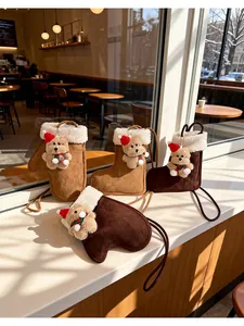 Detailed view of plush boot-shaped crossbody bags with cute teddy bear charms