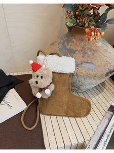 Detail of plush Christmas sock bag featuring a cute brown bear charm with a red hat