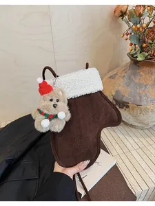 Detail of glove-shaped plush bag with white shearling trim and cute teddy bear charm