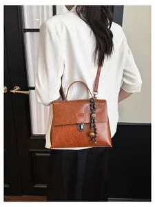 Braune Vintage-Umhängetasche aus geöltem Leder mit Metallschnalle und Anhänger