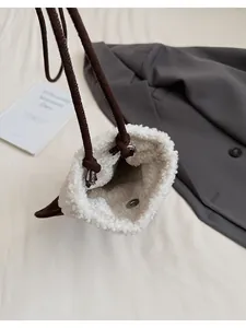 Detailed close-up of the plush bucket bag featuring a silver magnetic clasp and drawstring