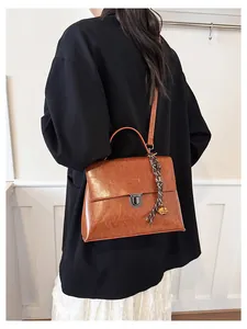 Detailansicht der braunen Öl-Wachs-Ledertasche mit Griff und Glockenanhänger-Zubehör