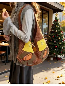 Detail of cute bear embroidery on brown knitted tote bag with soft woolen texture