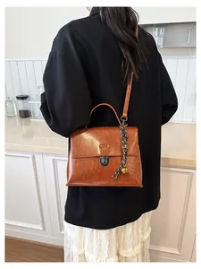 Details der braunen Vintage-Umhängetasche aus PU-Leder mit Schnalle und Anhänger