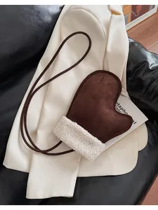 Detail of glove-shaped crossbody bag featuring dark brown suede and white fleece trim