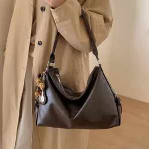 Détail du sac cabas Hobo marron foncé avec un charmant pompon en peluche léopard