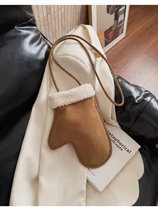 Detail view of mini mitten-shaped crossbody bag in brown suede with faux shearling trim