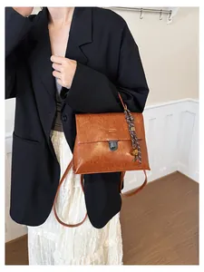 Detail einer Vintage-Handtasche aus braunem Leder mit Metalldrehverschluss und Flechtseil