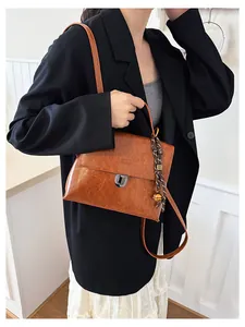 Detailansicht der braunen Vintage-Tasche mit silbernem Drehverschluss und Anhänger