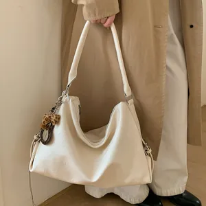 Détail du sac cabas blanc crème avec pendentif nœud léopard sur la bandoulière