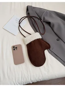 Detail of creative glove-shaped crossbody bag showing phone capacity and suede texture
