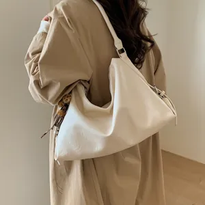 Détail du sac hobo crème en cuir souple avec pendentif léopard et bandoulière large