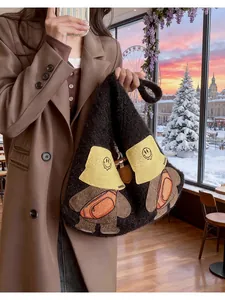Detail of soft black faux fur tote bag with cute bear embroidery and thick texture