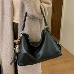 Détail du sac cabas en similicuir noir avec boucles argentées et breloque léopard