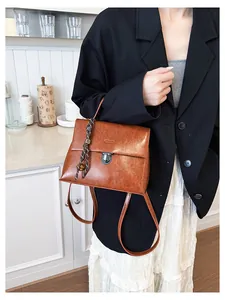 Detailansicht eines braunen Retro-Rucksacks aus Öl-Leder mit dekorativem Anhänger
