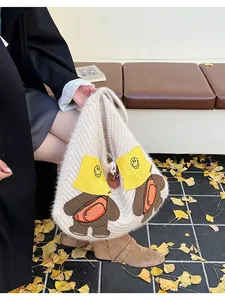 Detail of cute bear cartoon knitted tote bag featuring soft fleece texture and warm autumn vibe