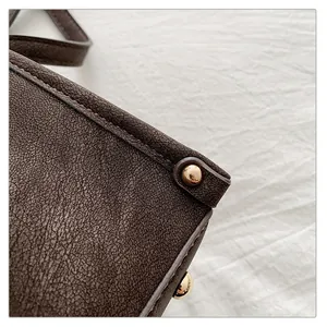 Close-up of vintage brown leather bag with high-quality gold hardware and fine stitching
