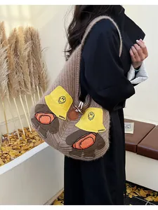 Detail of cute bear embroidery and thick knit texture on the brown shoulder tote bag
