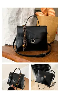 Detailansicht der schwarzen Vintage-Ledertasche mit Silberverschluss und geflochtenem Anhänger