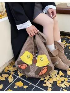 Detailed knit of brown tote bag with cute 3D cartoon bears on autumn ginkgo leaves