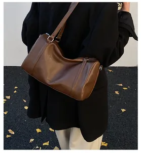 Détail du sac vintage en cuir marron montrant la texture et les ferrures métalliques