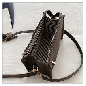 Top view of dark brown crossbody bag showing striped lining and internal zipper pocket