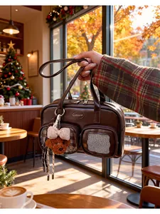 Détail d'un sac en cuir marron foncé avec un ours en peluche et des poches avant pratiques