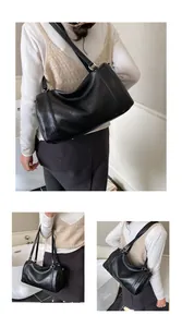 Détails du sac Boston noir à texture litchi avec double bandoulière et zip métallique