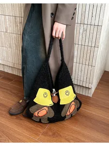 Detail of cute cartoon characters and leather buckle on a black plush tote bag