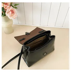 Detailansicht der schwarzen Ledertasche mit braunem Innenfutter und Reißverschlussfach