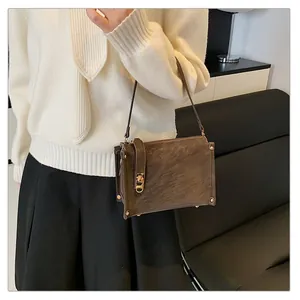 Detail shot of vintage dark brown square shoulder bag with elegant gold metal lock clasp