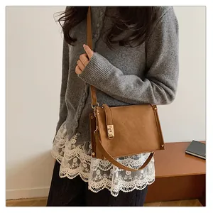 Classic brown leather square crossbody bag with gold hardware shown on a model