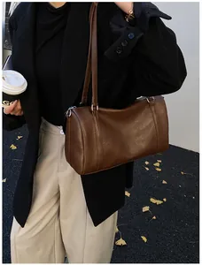 Sac à bandoulière Boston marron porté par un mannequin avec manteau d'hiver et pantalon beige