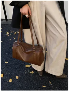 Détail du sac Boston vintage marron caramel en cuir PU mat avec anneaux argentés fins