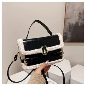 Sac baguette en similicuir noir avec bordure en polaire blanche et boucles dorées