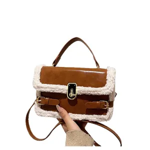 Sac baguette marron avec bordure en laine d'agneau et boucle métallique dorée chic