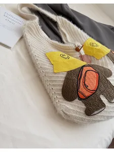 Close-up of knit shoulder bag featuring cute 3D cartoon embroidery and horn buckle closure
