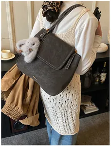 Detail of dark brown leather bucket bag with white contrast stitching and bunny charm