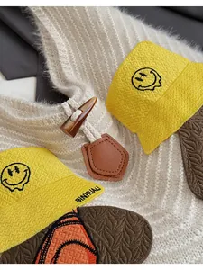 Detail of knit tote bag with wood toggle button and cute embroidered smiley patch