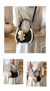 Detail of crescent handbag with white faux fur trim and cute bear mascot charm