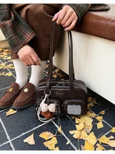 Détail d'un sac à bandoulière en cuir PU marron foncé avec poches et breloque ours mignon