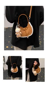 Detail of suede crescent bag with faux shearling trim and cute plush bear charm