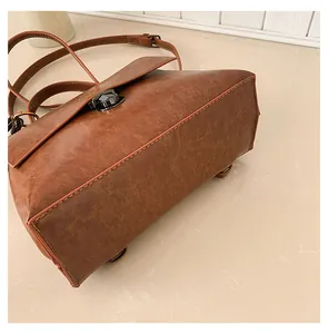 Nahaufnahme braune Vintage-Kuriertasche aus Leder mit grauem Metalldrehverschluss