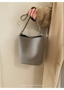 Close-up of grey litchi texture bucket bag with embossed HUIER & BAGS branding