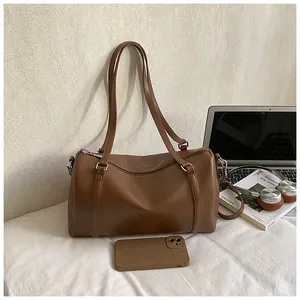 Sac Boston marron avec ordinateur portable, casque et magazine en décor de style