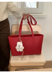 Detailed close-up of a large red textured PU tote bag featuring a cute white plush puppy charm