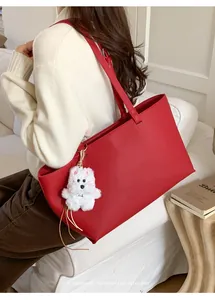 Detail of red large capacity PU tote bag with a cute white plush puppy pendant charm