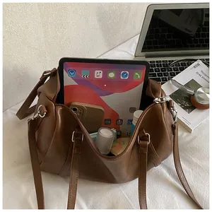 Sac Boston marron caramel montrant la capacité pour iPad et objets quotidiens