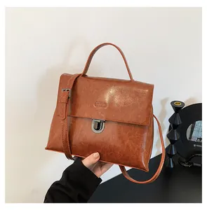 Detail der braunen Vintage-Handtasche aus Ölleder mit Metalldrehverschluss und Textur